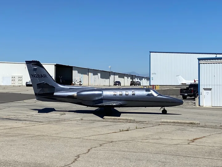 Dark metallic jet parked on airport ramp